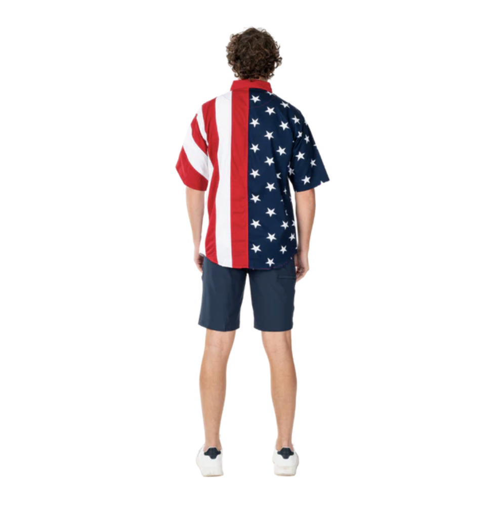 Stars & Stripes Harmony Button-Down: short-sleeve shirt with American flag print — stars on the right panel and stripes on the left, modeled from the back with navy shorts